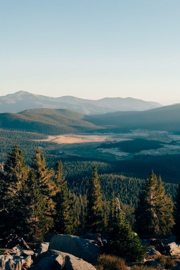 A view of a mountain range with trees and mountains in the background