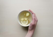 감기에 좋은 음식: 천연 치료제로 활용하기 person holding white bowl with sliced lime and ginger inside
