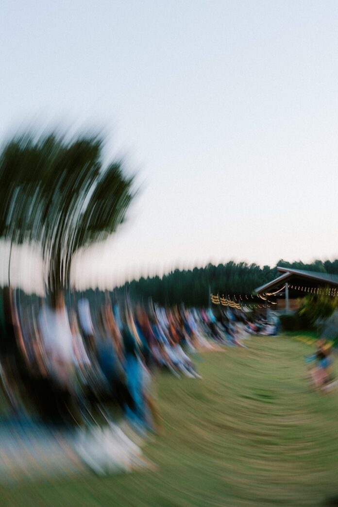 People gathered outdoors at dusk with blurred motion.