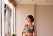 필라테스, 현대인의 건강을 책임진다… 일상에서 쉽게 실천하는 방법은? a woman in a green sports bra top and leggings holding a yoga mat