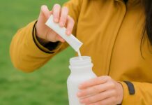 ‘똑똑하게 채우는 영양, 일상 속 나만의 맞춤 보충제 루틴’ Person pouring powder into a water bottle