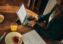 일상 속 정신건강, 작은 변화가 주는 큰 힘 Woman typing on laptop at wooden table with breakfast.