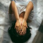 바쁜 일상 속 스트레스, 생활 습관으로 관리하기 a woman holds her hands over her face